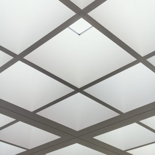 A low angle shot of the ceiling of a building made of bright lighted squares